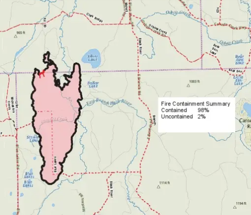 A topographic map on which the Blue Lakes Fire burn area is filled pink and outlined in a heavy black line. The burned shape is long and narrow, running roughly north to south and widening at its northern end, where its edge is ragged and lobed. Silver Lake and Dollar Lake lie just outside the eastern edge; the Blue Lakes and Blue Lakes Road lie off the south-western edge; the East Branch of the Black River runs along the north-east. A short stretch of the northern boundary is drawn in red instead of black. An inset box reads: Fire Containment Summary, Contained 98%, Uncontained 2%.